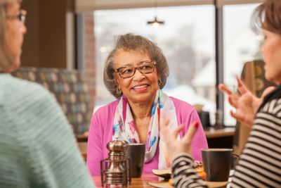 three women talking at a table