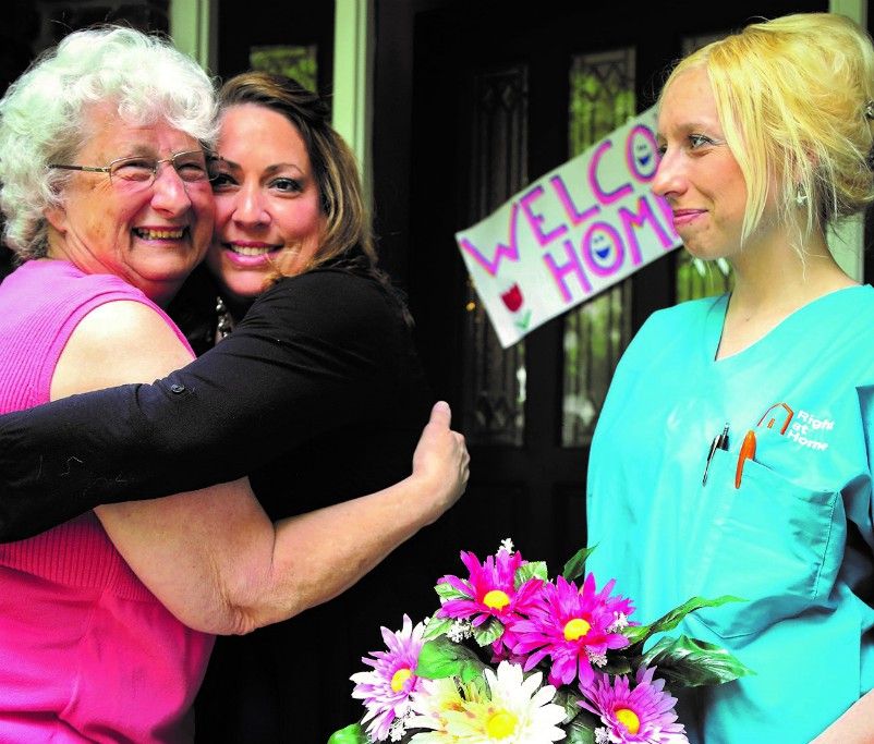 Caregiver with family members hugging