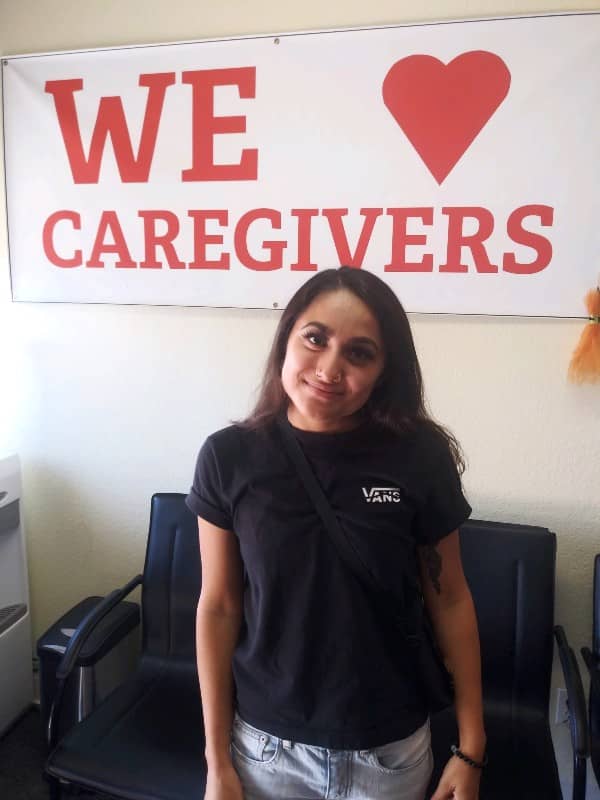 photo of Katarina standing in front of We heart Caregivers sign