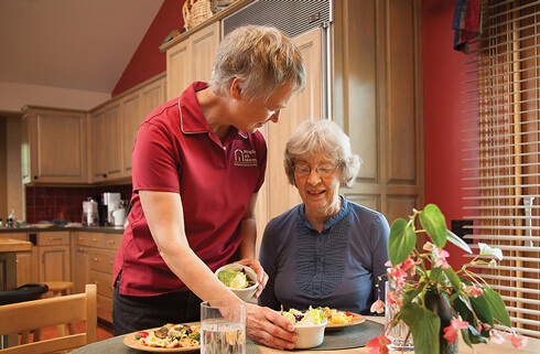 Caregiver serving lunch to client