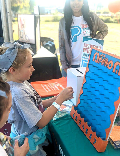 Girl playing Right at Home Plinko at Moving Day event 