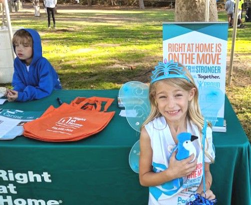 Girl in front of Right at Home Booth at Moving Day Event