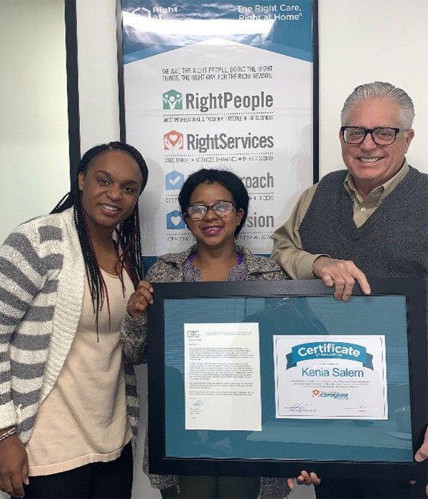 Kenia Caregiver of the Year Nominee holding framed certificate with Larry Anthony 