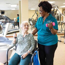 African American Caregiver Helping Senior Woman Exercise