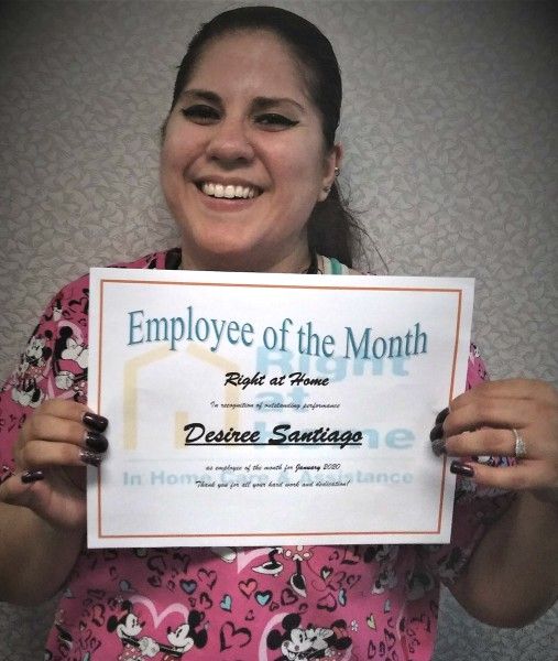 Desiree holding Caregiver of the Month certificate