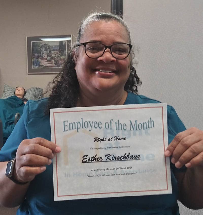 caregiver holding March 2021 employee of the month certificate