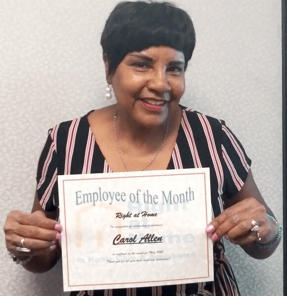 Carol A. holding Caregiver of the Month certificate