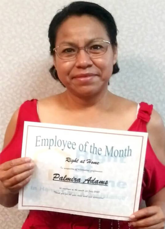 Profile photo of Palmira A. holding employee of the month certificate