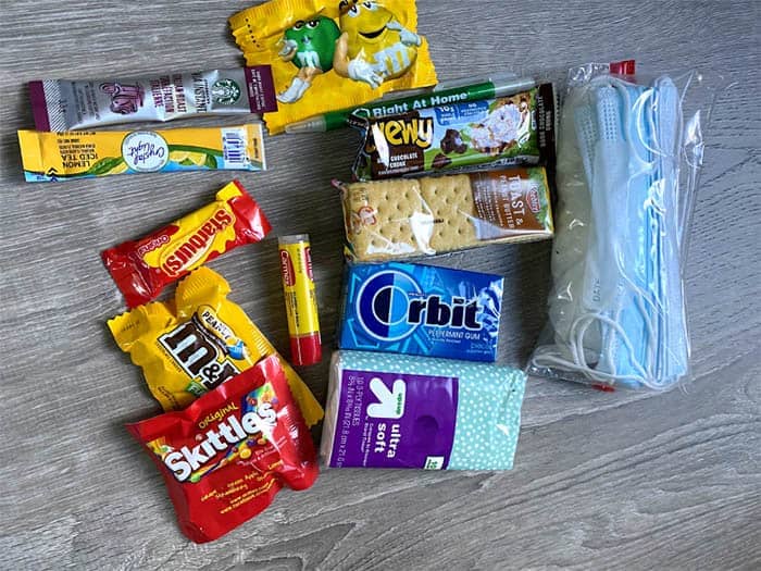 various snacks, candy and items including a mask for caregiver care packages