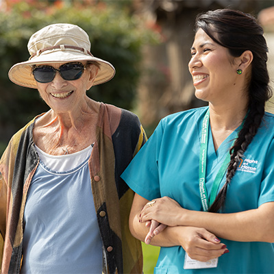 Female Caregiver Walking Outdoors With Female Client