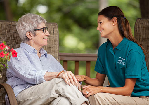 Female Client Sitting Outdoors With Female Caregiver