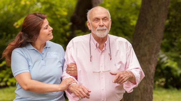 caregiver and senior walking outdoors