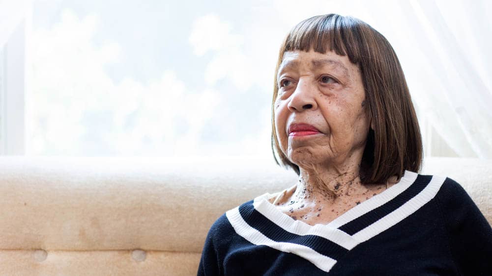 An African-American, senior female, sitting on a sofa