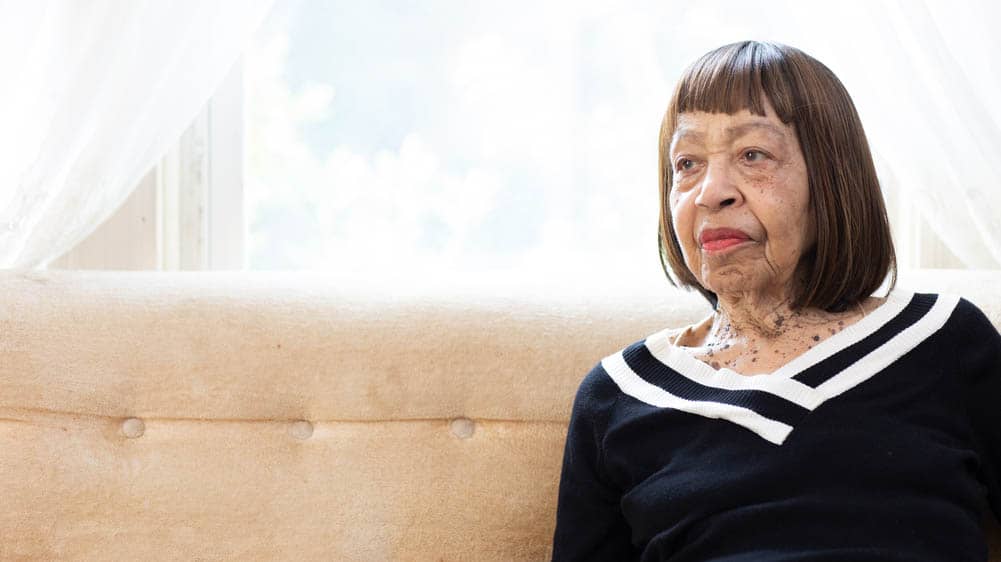 An African-American, senior female, sitting on a sofa