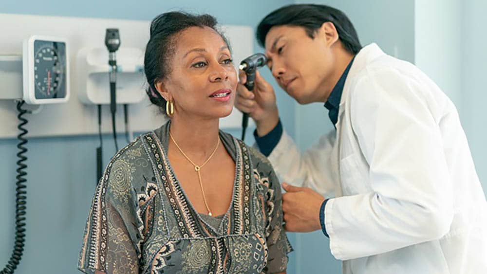 female having her hearing tested by a male doctor