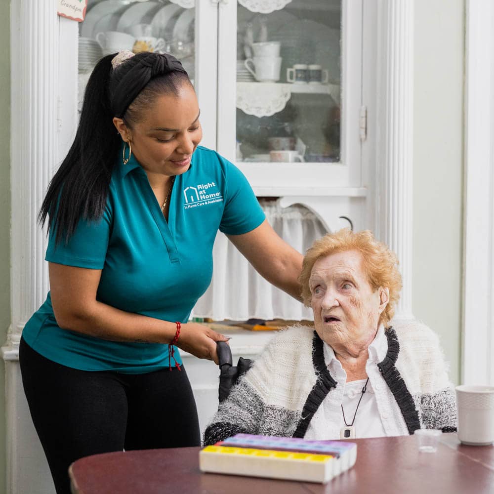 A Right at Home caregiver helping her elderly client.