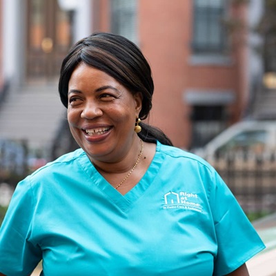 Caregiver standing outdoors smiling