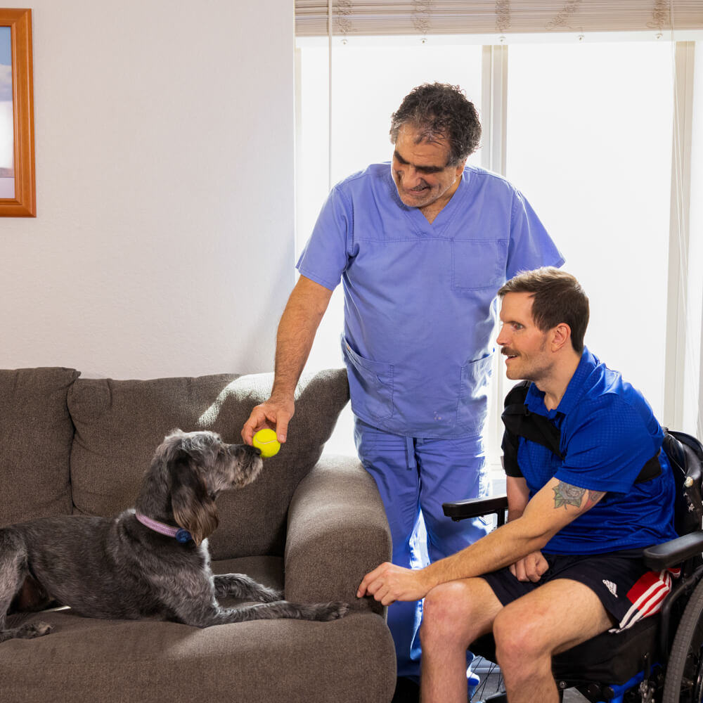 Right At Home Caregiver Working With A Disabled Veteran And His Service Dog