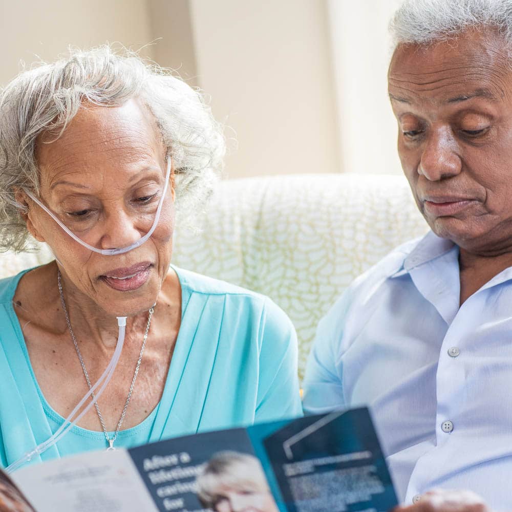Senior male and senior female reading a Right at Home brochure together