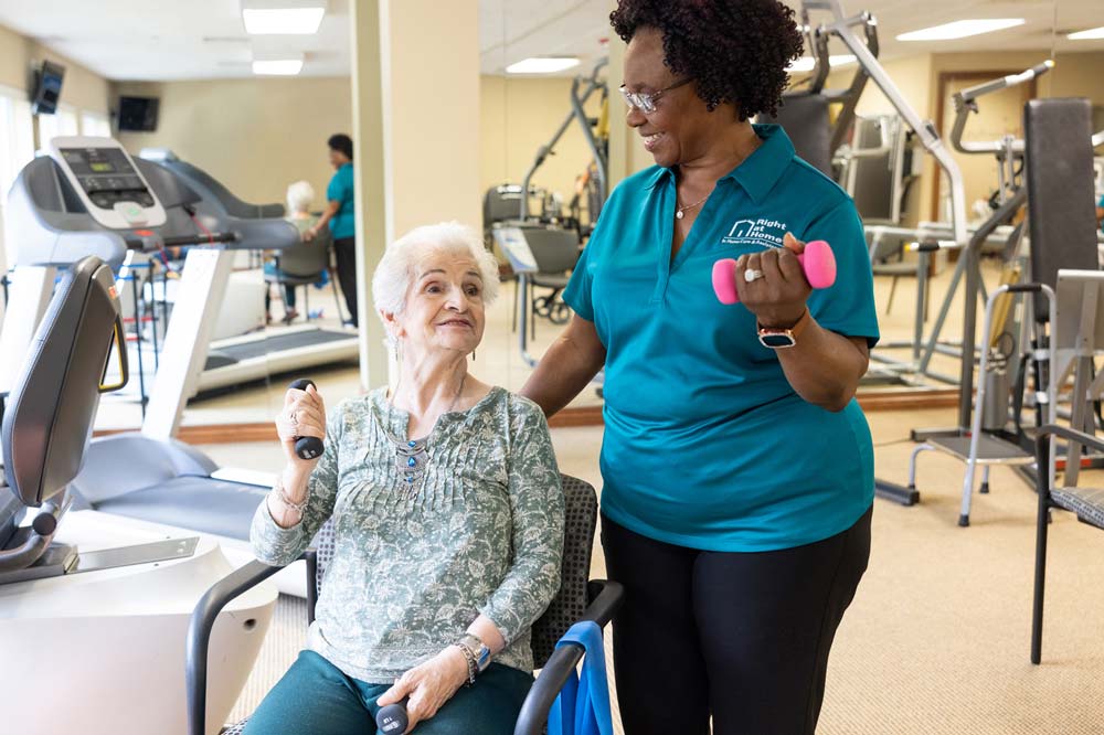 caregiver working out with senior with weights