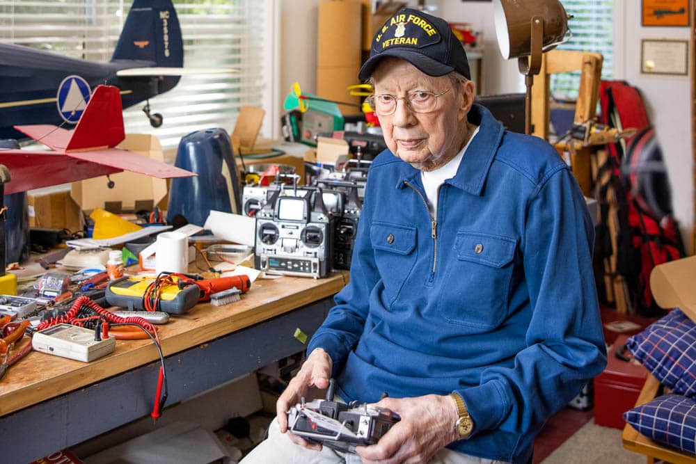 Veteran Senior Sitting in His Radio-Controlled Airplane Hobby Workshop