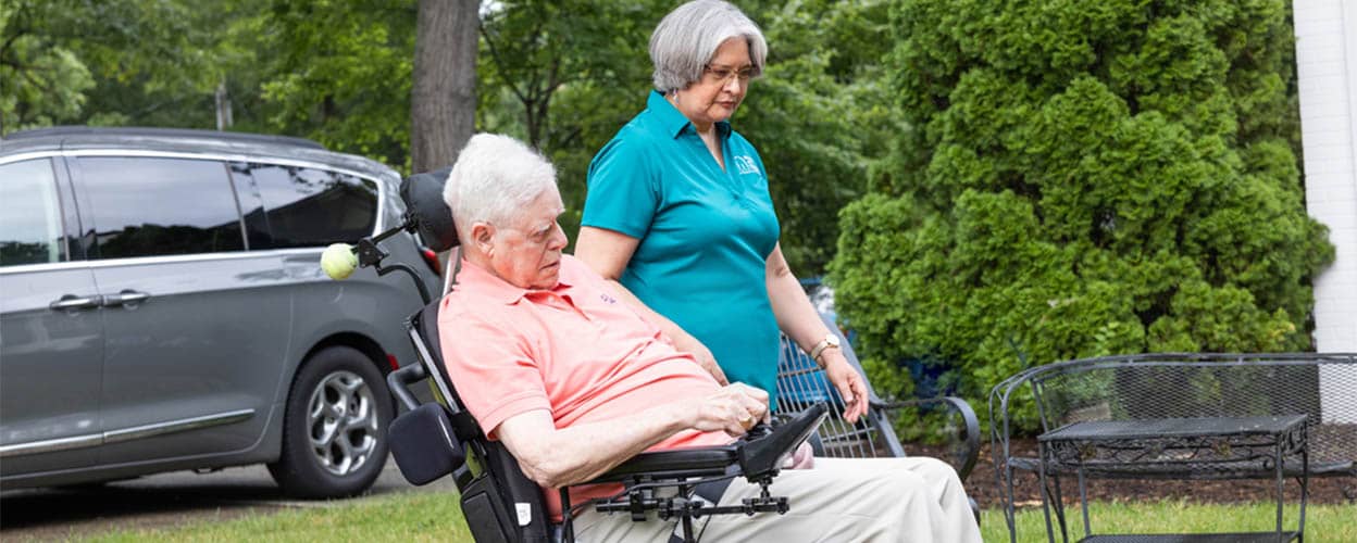 client in wheelchair caregiver outside