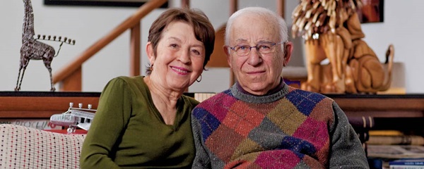 Senior male and senior female sitting together on a sofa in a living room