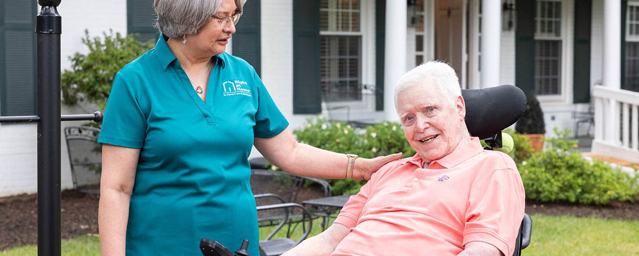 senior-man-in-powered-wheelchair-outside-with-female-caregiver-1