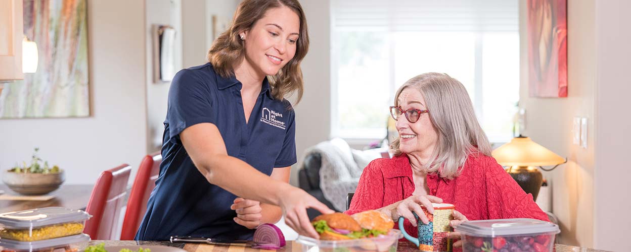 caregiver serving lunch to senior